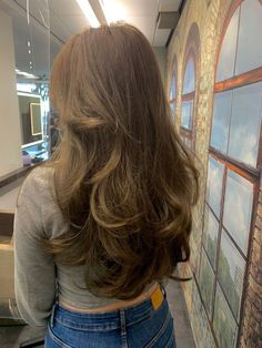 the back of a woman's head with long, wavy hair