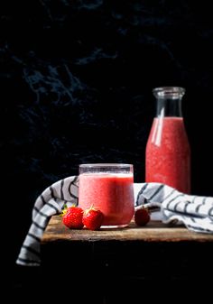 two glasses of strawberry smoothie on a wooden table