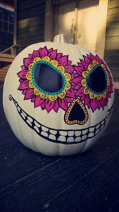 a decorated pumpkin sitting on top of a wooden table