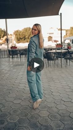 a woman standing on top of a brick floor