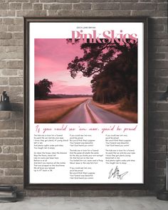 an advertisement for the pink skies magazine hangs on a brick wall next to a lamp