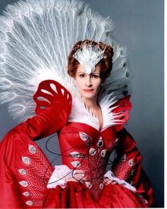 a woman in a red dress with white feathers on her head