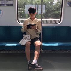 a man sitting on a train reading a book