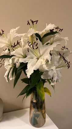 a vase filled with white flowers on top of a table