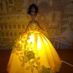 a lighted doll in a yellow dress with flowers on it's chest and head