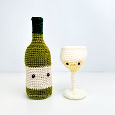 a crocheted wine bottle and glass sitting next to each other