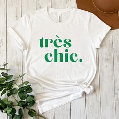 French Fashion Très Chic Tshirt, Statement Shirt, French Quotes Shirt, Bonjour Shirt, La Vie en France Tshirt, envogue Fashion Shirts, Summer Shirts for Women, Fashion Shirts for Girls Make a statement with this trendy T-shirt. The green front print is a real eye-catcher! Details: ❤ large front print ❤ Unisex - for everybody :) ❤ classic round neck ❤ lightweight breathable fabric ❤ Close-fitting cut - please note the measurements Material: 100% cotton ❤ Care instructions ❤ To ensure that you can Tshirt Statement, Chic Quotes, Summer Shirts For Women, Quotes Shirt, Fashion Shirts, Shirts Summer, French Quotes, Statement Shirt, Gifts For Teachers