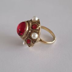 Lovely vintage cocktail ring. Antique style, large red cabochon and faux pearls. Adjustable and in good vintage condition. For new arrivals check the shop's Instagram account https://www.instagram.com/helensjewellerybox/ All jewelry may have light scratches due to age. Thank you for looking and if you have any questions please don't hesitate to ask :) Vintage Cabochon Pearl Ring For Wedding, Vintage Red Cabochon Ruby Ring, Vintage Cabochon Ruby Ring Gift, Vintage Cabochon Ruby Ring As Gift, Red Vintage Jewelry With Cabochon, Vintage Ruby Ring Gift, Vintage Pearl Ring For Gift, Retro Red Ring Jewelry, Vintage Cabochon Ruby Ring