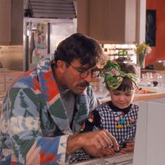 a man and child looking at a computer screen