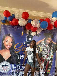 a woman standing in front of a banner with balloons