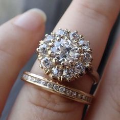 a close up of a person's hand with a ring and wedding band on it