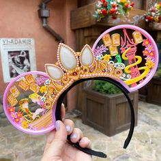 a hand holding up a minnie mouse ears headband