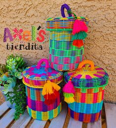 three colorful baskets sitting on top of a wooden table