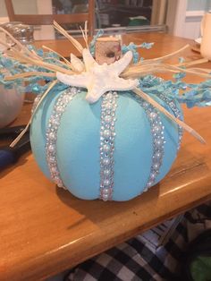 a blue pumpkin decorated with pearls and bows