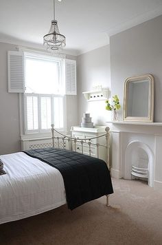 a bedroom with a bed, mirror and fireplace in it's centerpieces