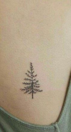 a small pine tree tattoo on the back of a woman's stomach