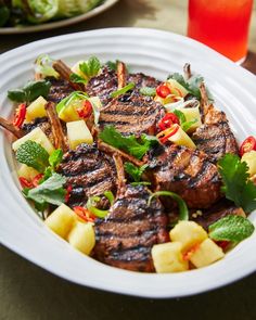 a white plate topped with steak and pineapple salad