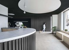 a woman walking her dog in an open kitchen area with black and white decor on the walls