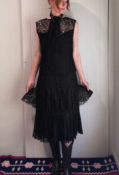 Live out your romantic goth dreams in this most magical, witchy, ethereal antique gown🖤🗝️ This 1930s beauty features a white sheer lace panel under the bodice and two tiers of black lace ruffles on the skirt. It's fully lined and in impeccable condition for its age. Comes with a sweet little matching black lace sash that can be worn around your neck, in your hair or even as a belt.  Measurements are taken across garment flat. Please double where needed. Shoulders: 17" Armpit to armpit: 21" Waist: up to 21" Hips: up to 22" Overall length: 46" 1930s Beauty, Black Midi Lace Dress With Ruffles, Luxury Black Midi Dress With Scalloped Lace, Black Lace Trim Witchy Dress, Black V-neck Scalloped Lace Dress, Black Knee-length Dress With Scalloped Lace, Lace Sash, Beauty Features, Romantic Goth