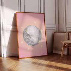 a mirror with a disco ball on it in front of a wooden chair and wall