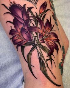 a woman's leg with tattoos on it and flowers in the middle of her thigh