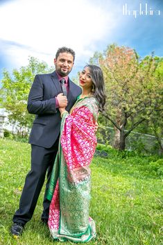 a man and woman are standing in the grass