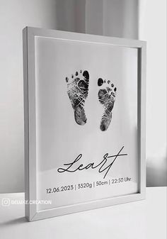 a glass frame with a baby's hand and foot prints on the front side