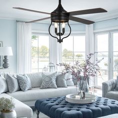 a living room filled with furniture and a ceiling fan