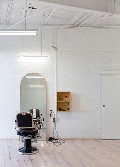 an empty room with white brick walls and wooden floors, including a hair dryer