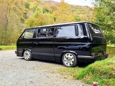 a black van parked on top of a gravel road