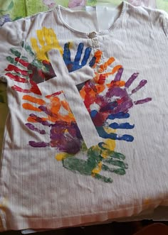 a t - shirt with handprints on it sitting on top of a bed