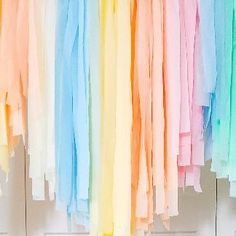 a bunch of different colored clothes hanging on a line next to a white door with the word love written on it