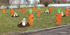 carrots are growing out of the ground with sticks sticking out of them in front of a house