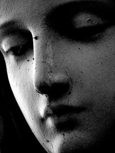 a close up of a statue's face in black and white with eyes closed