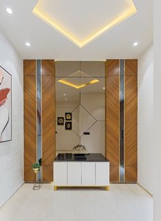 a kitchen with white cabinets and black counter tops in front of a painting on the wall