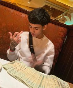 a person sitting at a table with stacks of money