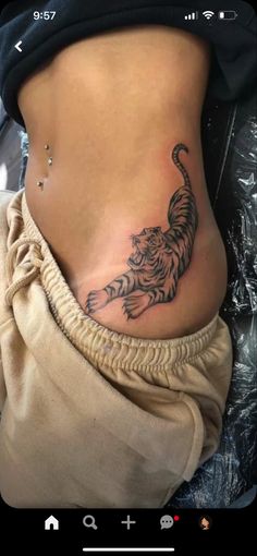 a woman's stomach with a tiger tattoo on her belly and the bottom part of her lower body