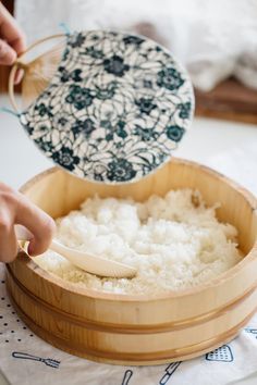 a person scooping rice into a wooden container with the words how to make sushi rice