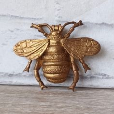 a golden bee is sitting on the wall