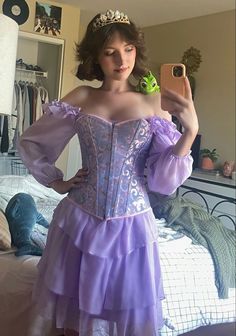 a woman in a purple corset is taking a selfie with her cell phone