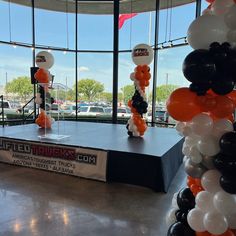 balloons and streamers decorate the entrance to an event in front of a large window