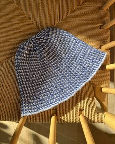 a blue and white hat sitting on top of a wooden chair