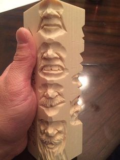 a hand is holding a carved piece of wood