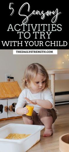 a toddler sitting on the floor playing with food and drinking from a yellow cup