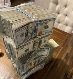 a stack of money sitting on top of a wooden table