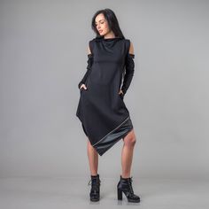 "The Asymmetrical Tunic Dress is a modern masterpiece, featuring an eye-catching design with an asymmetrical hemline and two convenient pockets. Its cold shoulder long sleeves are adorned with intricate details, adding an elegant and edgy touch. This plus-size dress incorporates eco-leather elements for a bold statement and is made from Punto di Roma thick jersey fabric, ensuring both luxury and durability. Ideal for any event or as a thoughtful gift, this classic black dress promises effortless style and comfort on any occasion. ^ Sizes: The item can be made in sizes from XXS to 7XL. Please, use the size chart below or if you are not sure about your size, just * contact us with your measures! ^ Estimated delivery times: It takes us up to 3 days to make and ship this item. Standard deliver Black Knee-length Asymmetrical Dress For Fall, Avant-garde Summer Dress With Asymmetrical Hem, Black Oversized Dress With Asymmetrical Hem, Black Mini-length Asymmetrical Dress, Avant-garde Black Dress With Asymmetrical Hem, Dress Extravagant, Turtleneck Tunic, Dress Loose Fit, Loose Fit Dress