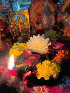 there is a candle and some flowers on the table with other decorations in the background