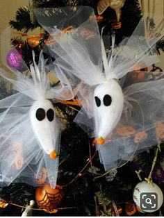 two white plastic ghost heads on top of a christmas tree