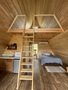 there is a loft with stairs leading up to the bed and kitchen in this tiny cabin