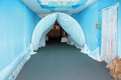 a room with blue walls and white drapes on the ceiling that have been set up to look like an arch